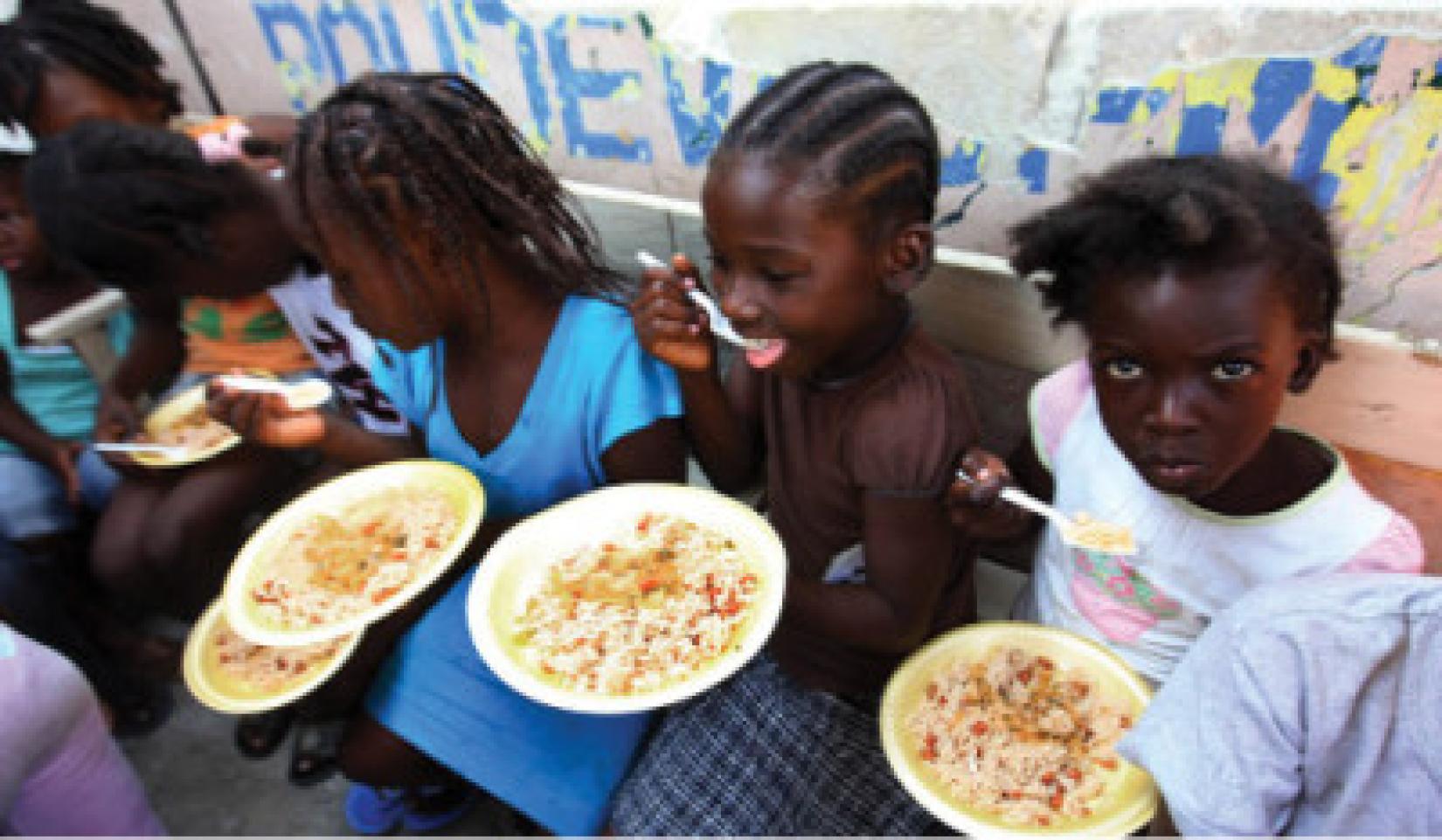 Crianças fazem refeição, na comunidade de Bel Air, em Porto Príncipe, no Haiti. Foto: MINUSTAH