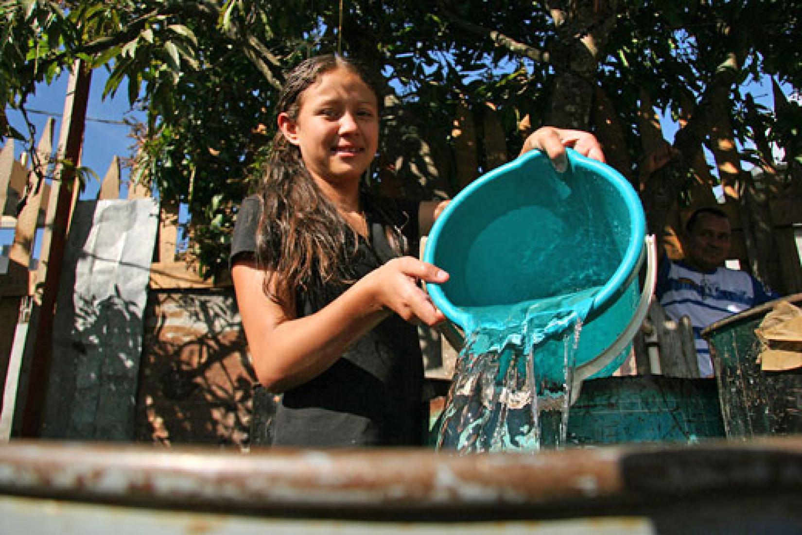 Menina enche um recipiente com água em Honduras. Foto: Banco Mundial