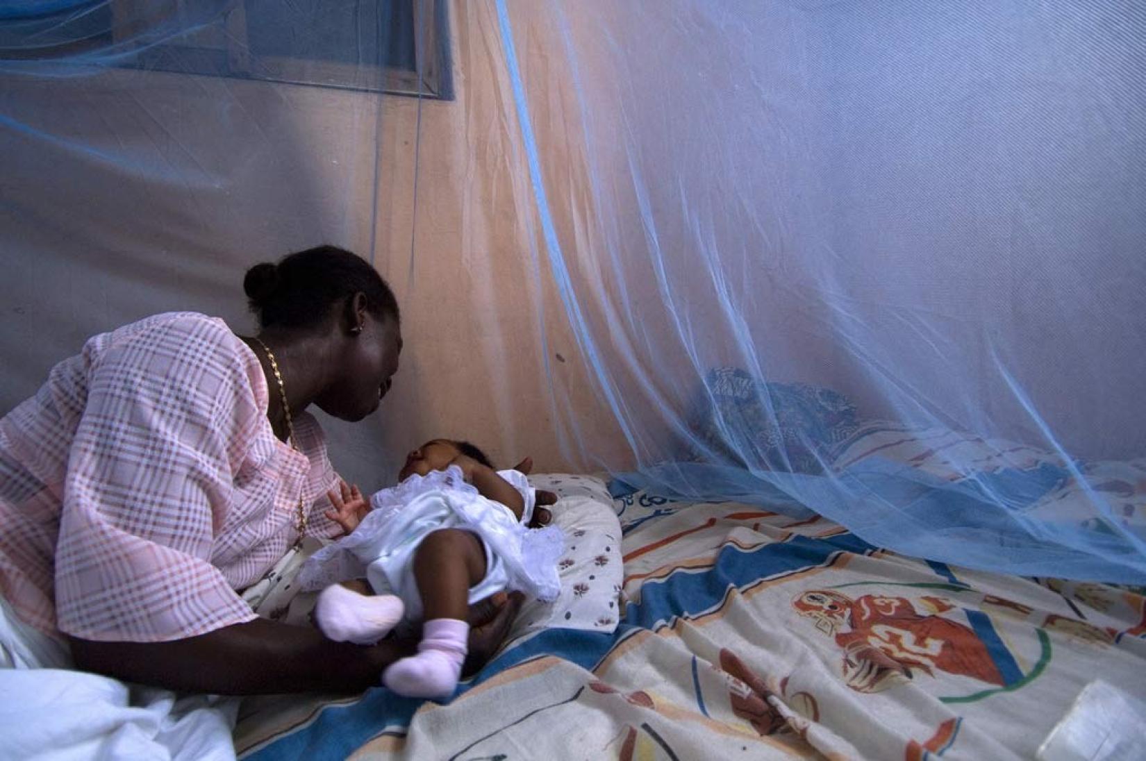 O uso de redes é um método eficaz de proteção contra o mosquito da malária. Na foto, um bebê com sua mãe em Gana. Foto: Banco Mundial/Arne Hoel