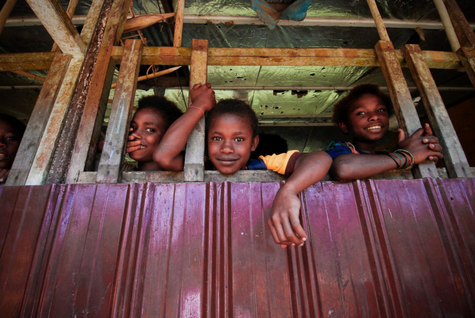 Meninas olham pela janela de casa em favela da Papua Nova Guiné. Foto: Asian Development Bank