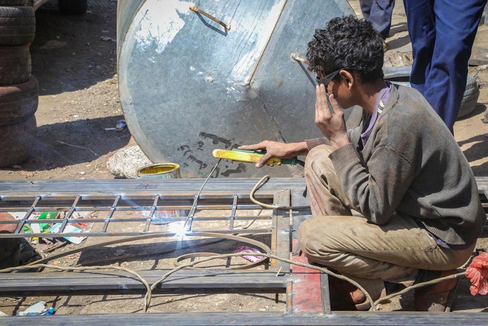 Menino de 15 anos trabalha soldando quadro em Sanaa, no Iêmen. Foto: UNICEF/Al-Zikri