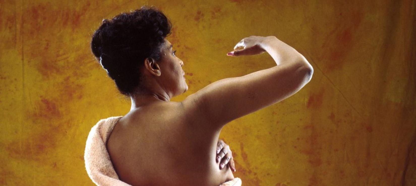 Mulher realiza autoexame preventivo de câncer de mama. Foto: National Cancer Institute/Bill Branson