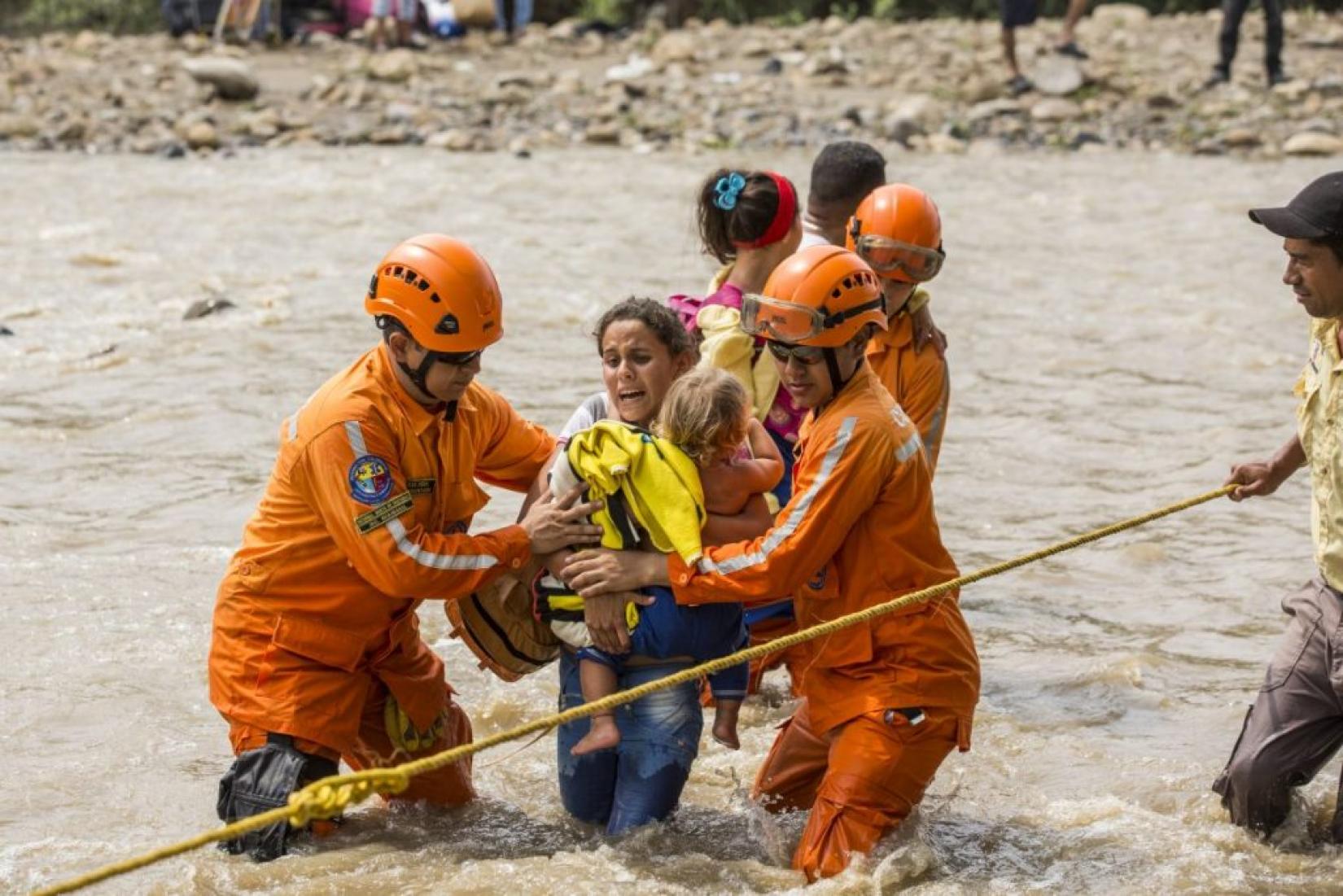 Uma mãe segura seu bebê para atravessar o rio e a fronteira com a Colômbia. Foto: ACNUR/Vincent Tremeau