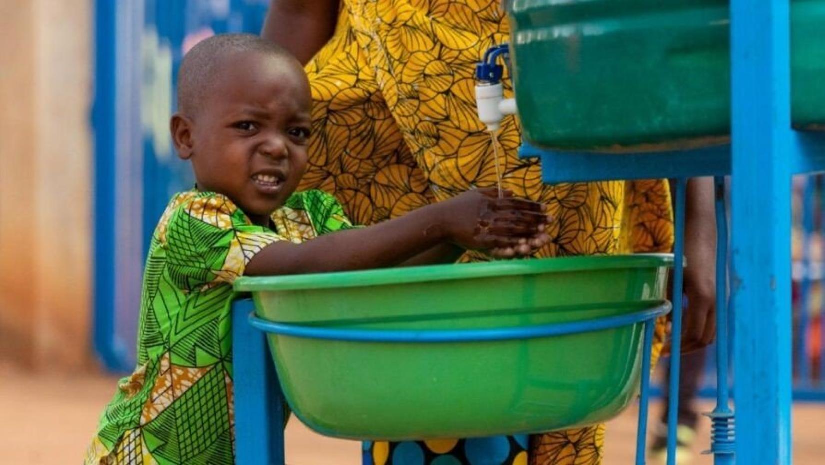 Criança do Burundi lava as mãos no campo de refugiados Mahama, em Ruanda, agosto 2020. 
