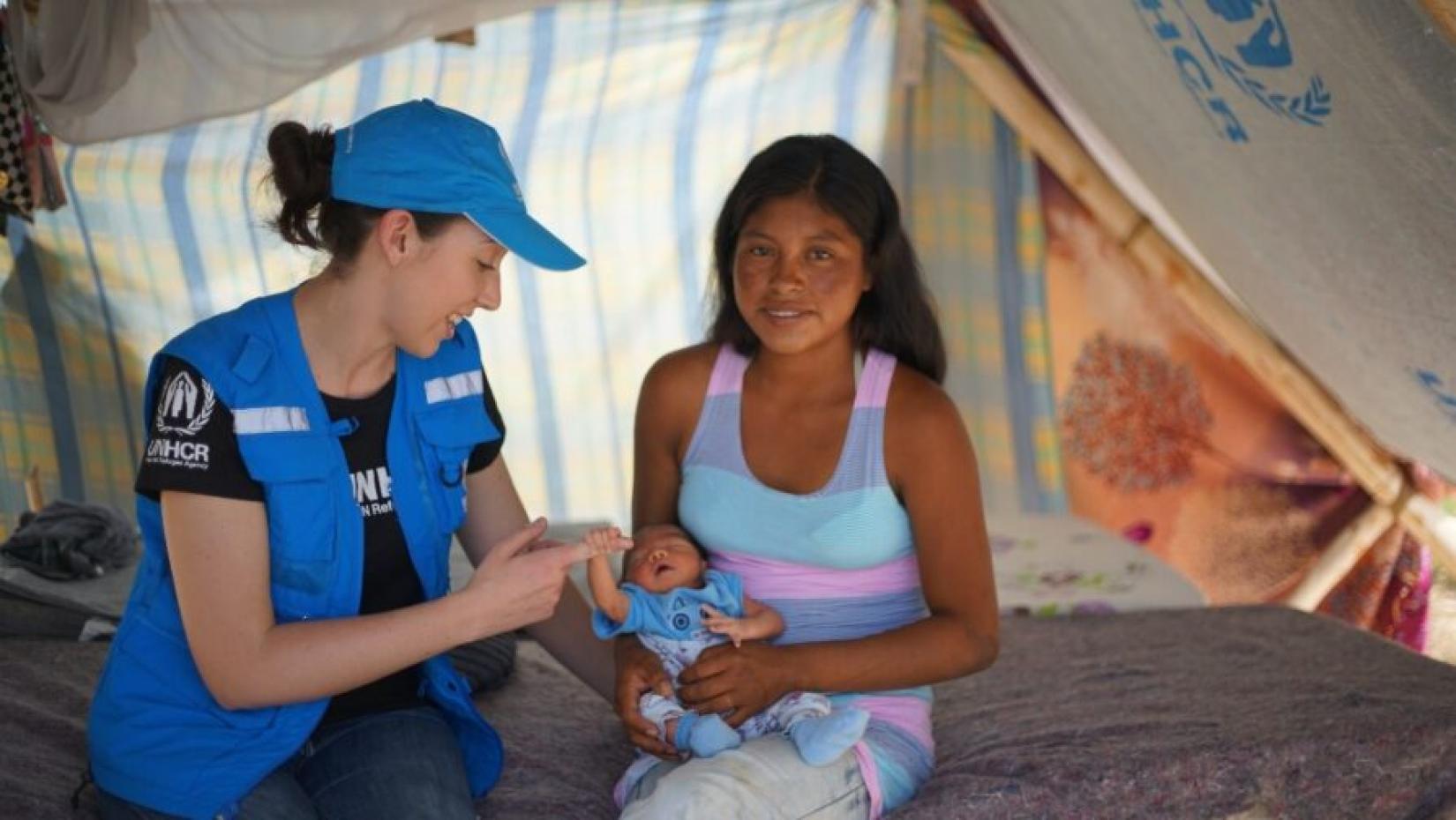 Funcionária do ACNUR conversa com Magdalena, refugiada venezuelana que vive em uma comunidade indígena no Brasil. 