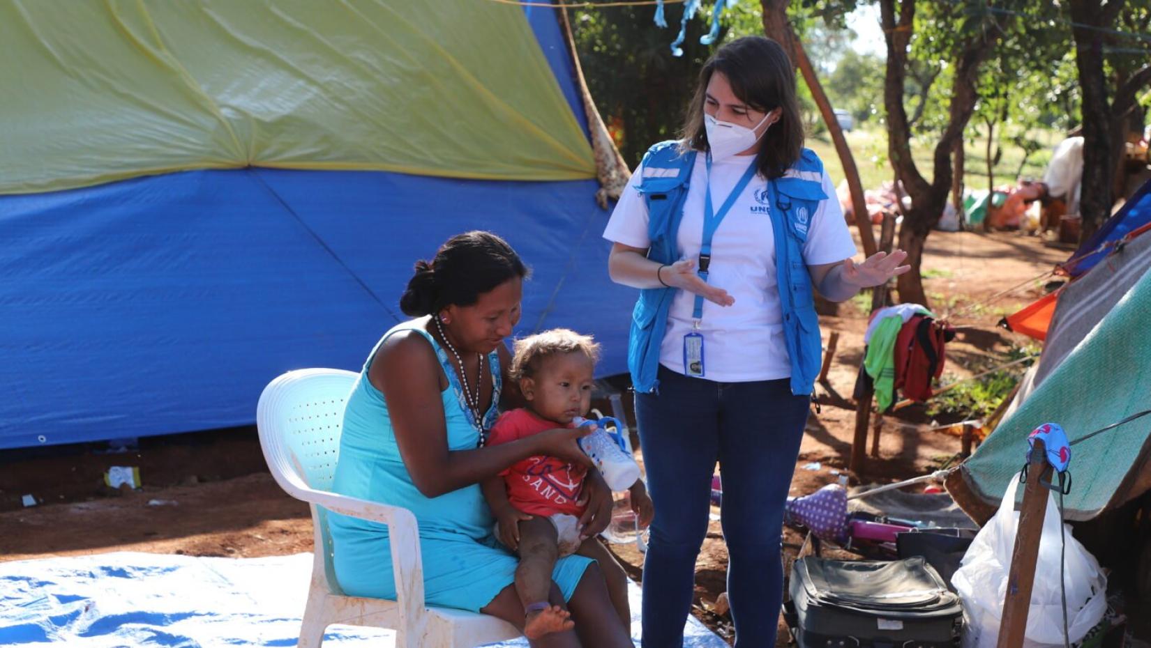 A índia venezuelana Yulitza Maria Quijada Zapate com o filho Marcelino recebem apoio do ACNUR no processo de realocação para o novo abrigo. 