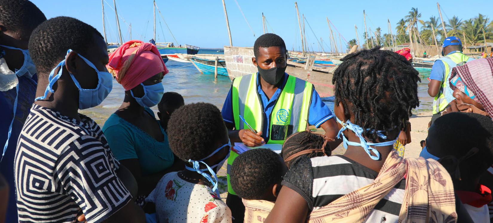 Em Moçambique, pessoas deslocadas internamente que fogem da insegurança em Cabo Delgado chegam de barco na praia de Paquitequete, em Pemba.
