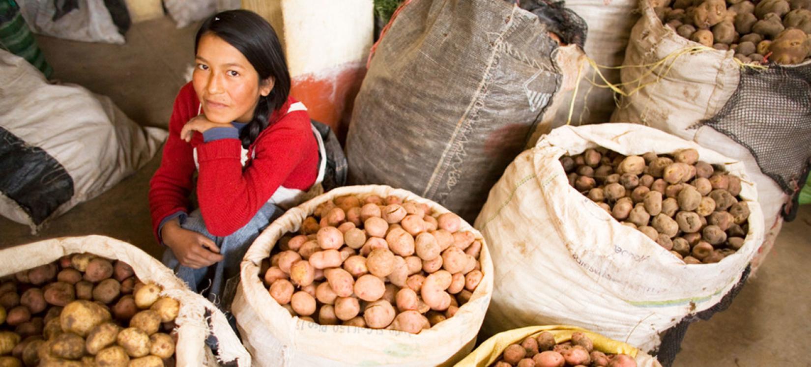 Uma mulher vende batatas no mercado de alimentos Andahuaylas, no Peru