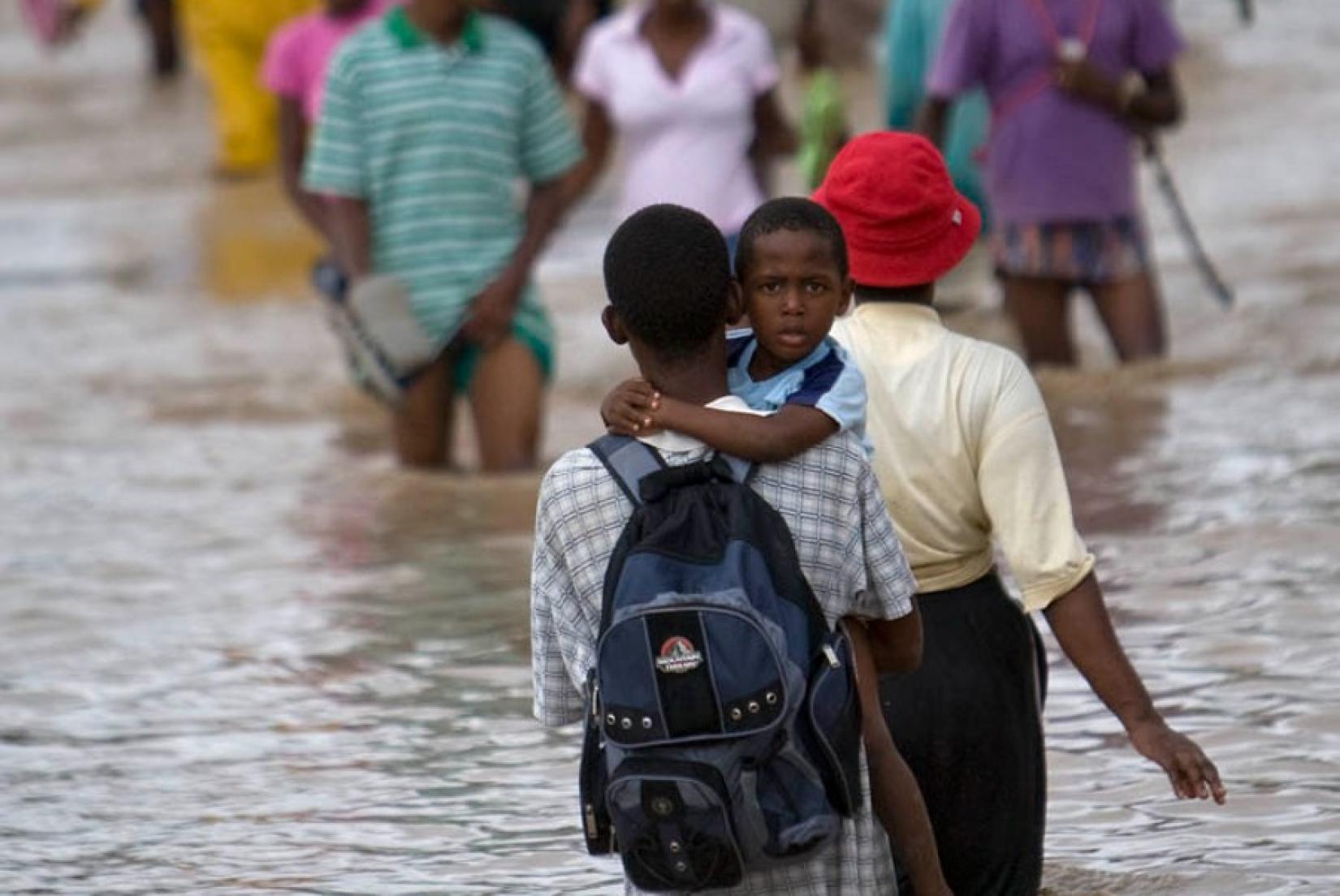 migrantes haitianos cruzam área alagada
