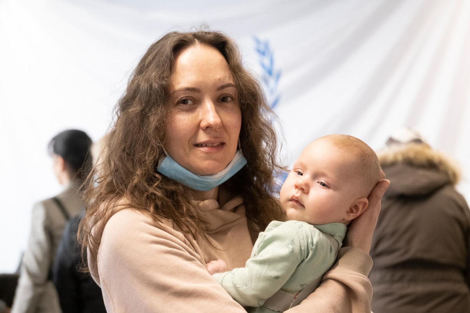 Kateryna Koval e a filha Victoria em um centro de assistência financeira do ACNUR para refugiados da Ucrânia em Varsóvia, Polônia. 