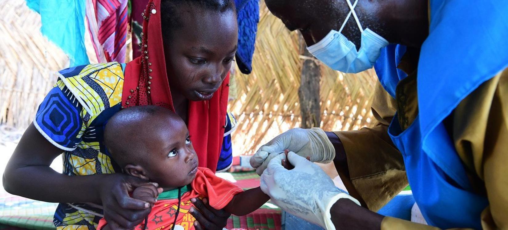 Um bebê é testado para malária em um centro de saúde comunitário no Chade.