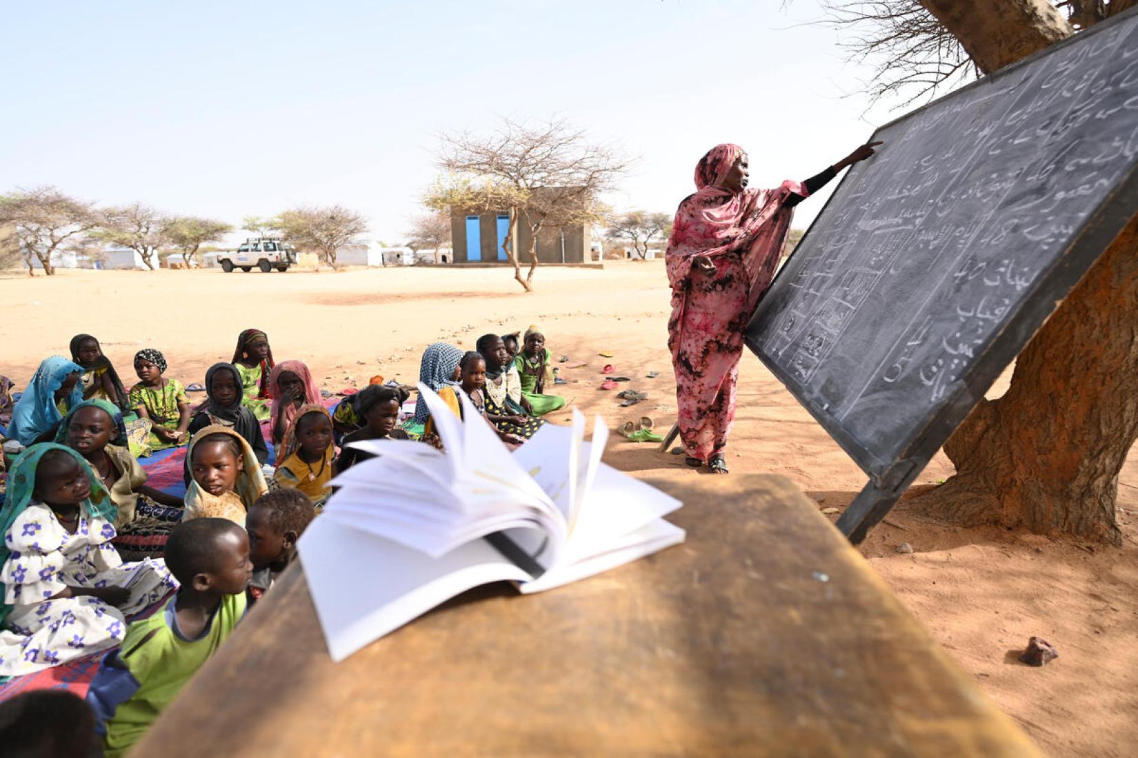 A professora refugiada Hassanie Ahmad Hussein dá uma aula ao ar livre na escola no campo de refugiados de Kouchaguine-Moura, no leste do Chade.