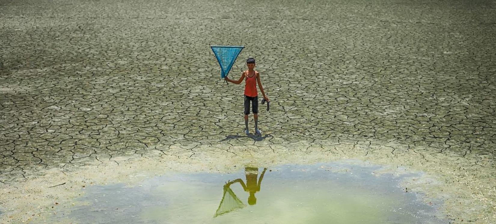 Menino em uma zona de seca em Bangladesh. Condições do La Niña envolvem um resfriamento em larga escala das temperaturas.