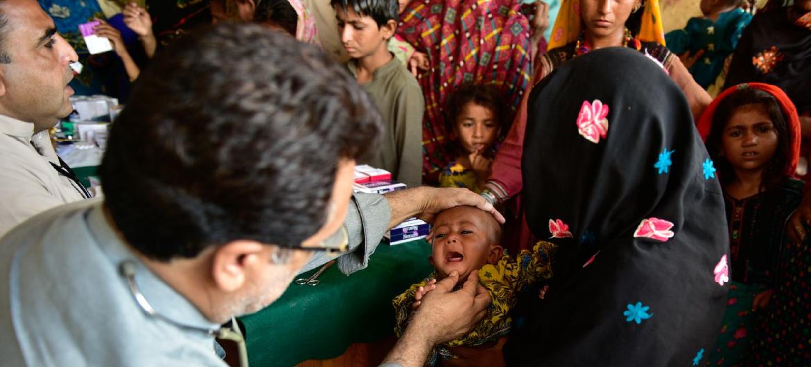 Crianças afetadas por inundações no Paquistão sendo examinadas por especialistas em saúde.  