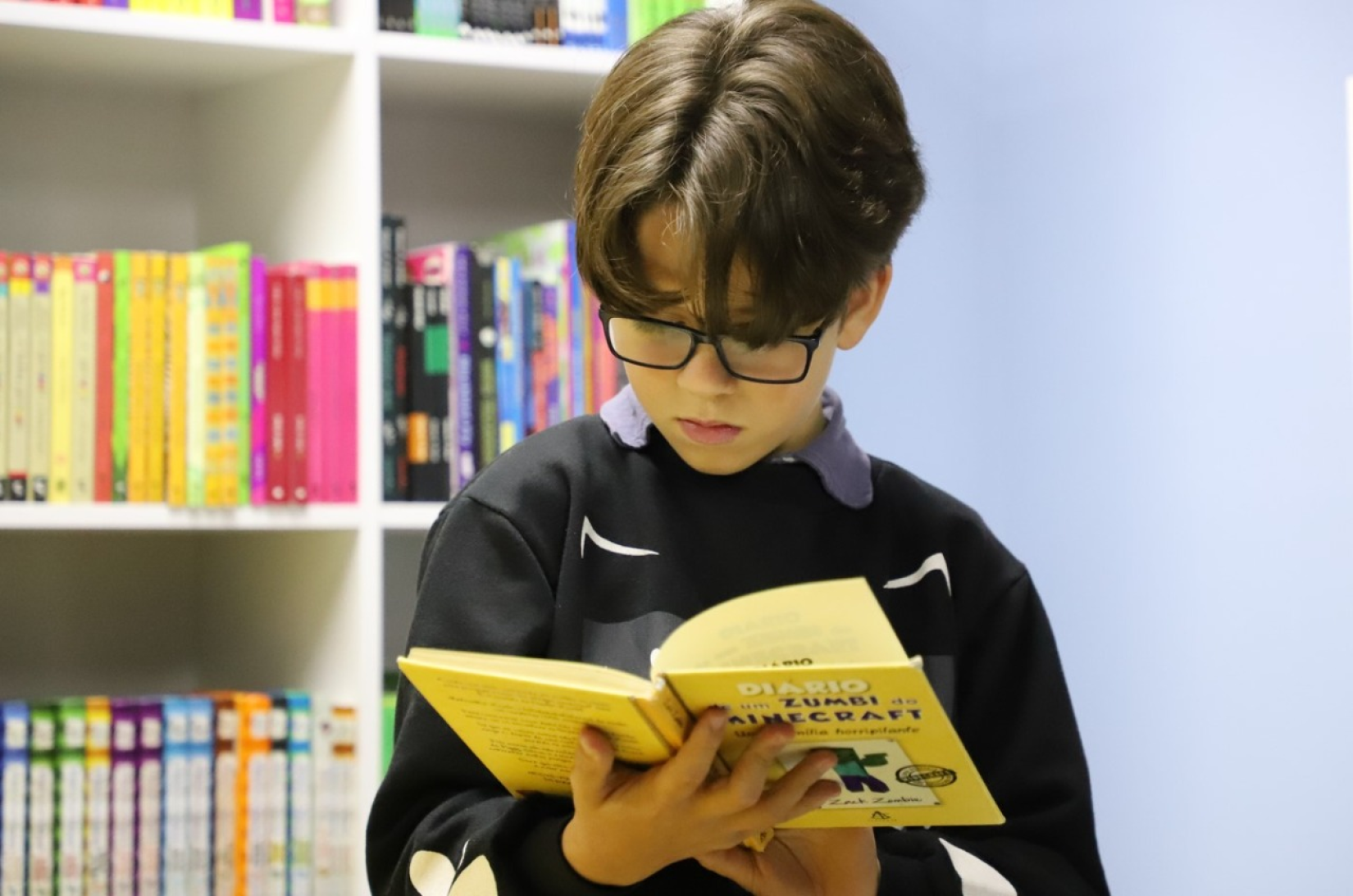 Jovem refugiado da Venezuela escolhe seu primeiro livro da biblioteca inaugurada em um abrigo que acolhe pessoas de diferentes nacionalidades em São Paulo. 