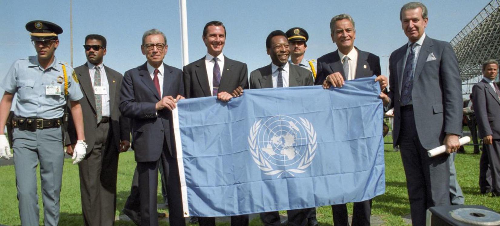 O astro do futebol Pelé e outras autoridades brasileiras são presenteados com a bandeira das Nações Unidas pelo ex-secretário-geral da ONU Boutros Boutros-Ghali