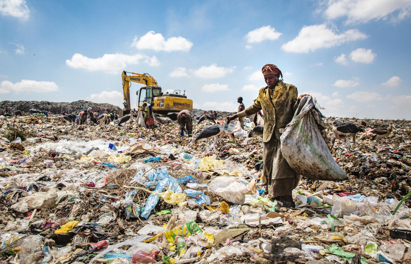 Em Nairóbi, capital do Quênia, mulher busca materiais recicláveis num lixão a céu aberto. 