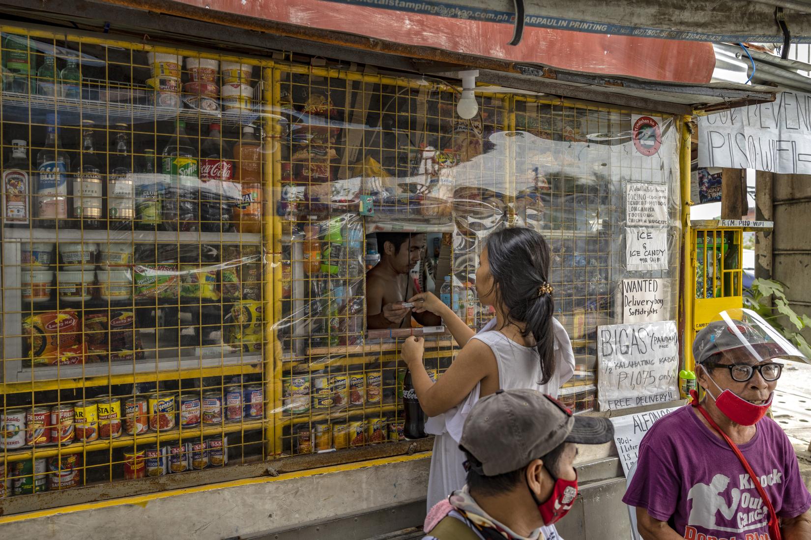 Uma mulher compra em um quiosque na vila costeira de Talaba Dos em 16 de setembro de 2021 em Bacoor, província de Cavite, Filipinas.