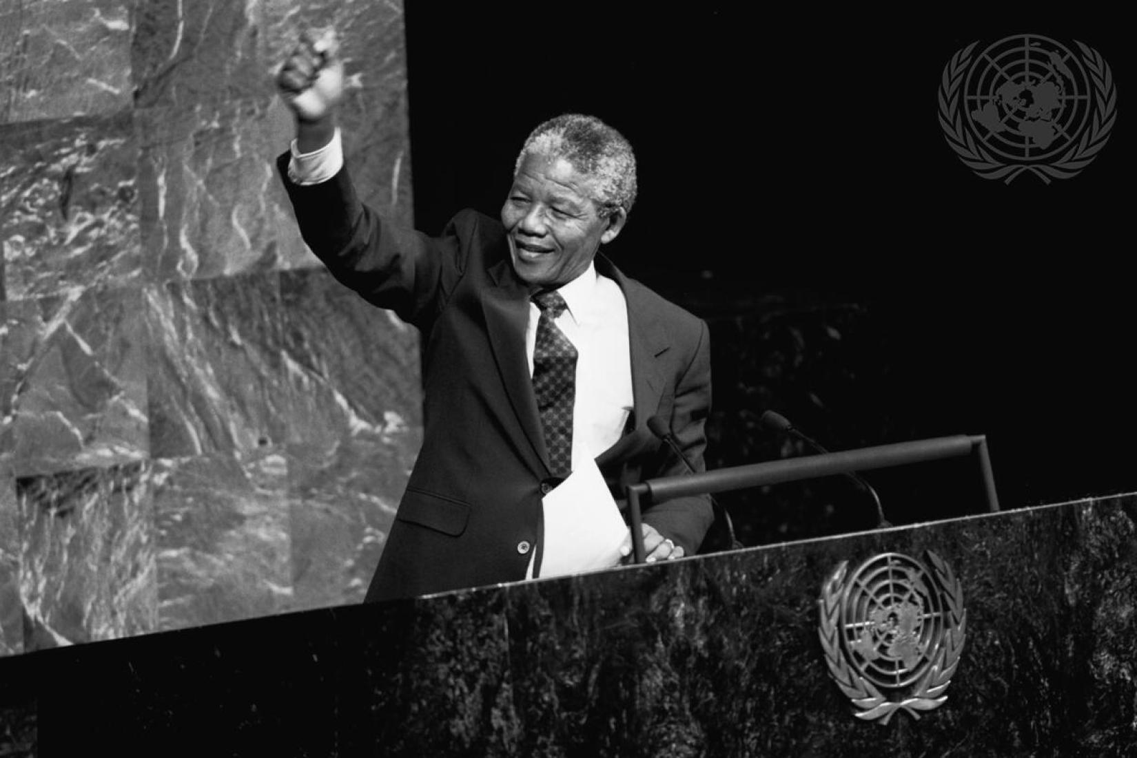 “Nossa marcha para a liberdade é imparável. Não podemos permitir que o medo se coloque em nosso caminho”.  Foto: Nelson Mandela, vice-presidente do Congresso Nacional Africano da África do Sul, levanta o punho no ar enquanto discursa para o Comitê Especial contra o Apartheid no Salão da Assembleia Geral das Nações Unidas. Foto: © ONU/Pernaca Sudhakaran