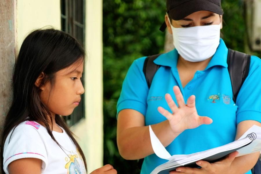 Menina de 11 anos recebe um guia de estudos durante a pandemia da COVID-19, porque as escolas estão fechadas no Equador. 