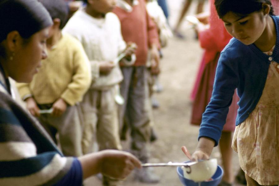 Crianças fazem fila para uma refeição diária em área carente do Equador.