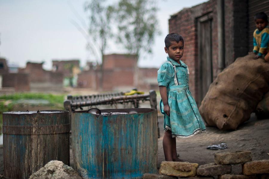 Criança brinca numa favela em Uttar Pradesh, Índia