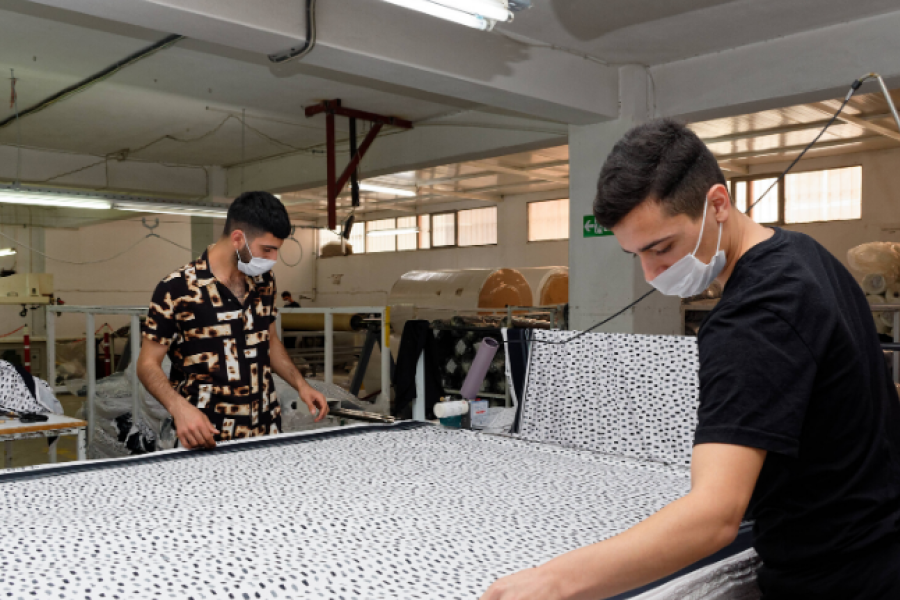 Jovens trabalham no setor têxtil