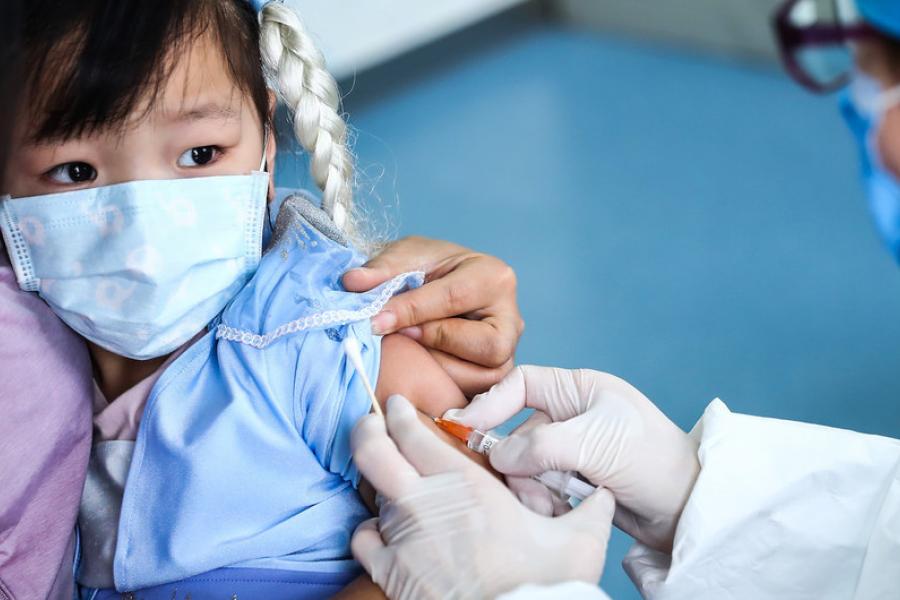 Garota de três anos é vacinada num centro de saúde em Beijing, China