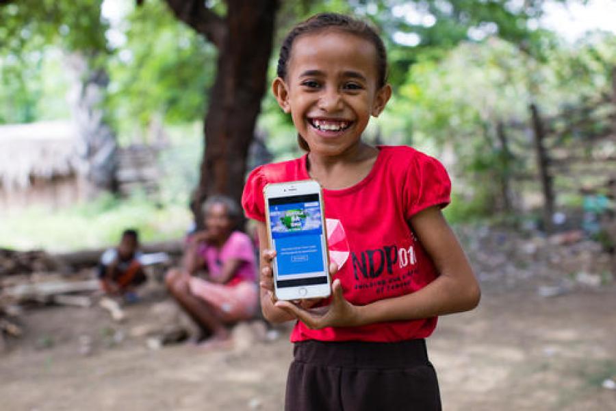 No Timor Leste, garota acompanha aulas em plataforma online pelo celular durante pandemia da COVID-19.