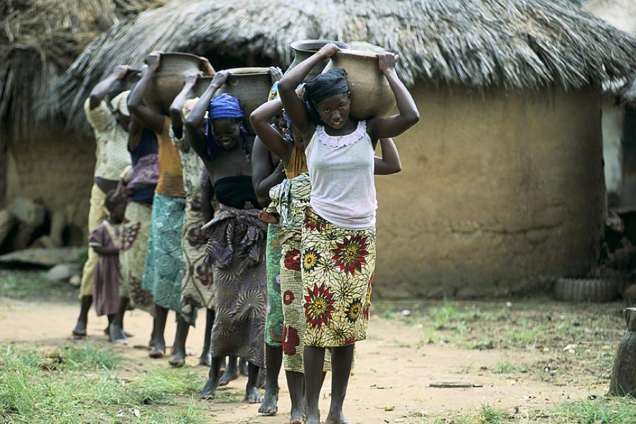 Mulheres foram mais afetadas pela pandemia da COVID-19. Aqui, elas carregam água na Nigéria