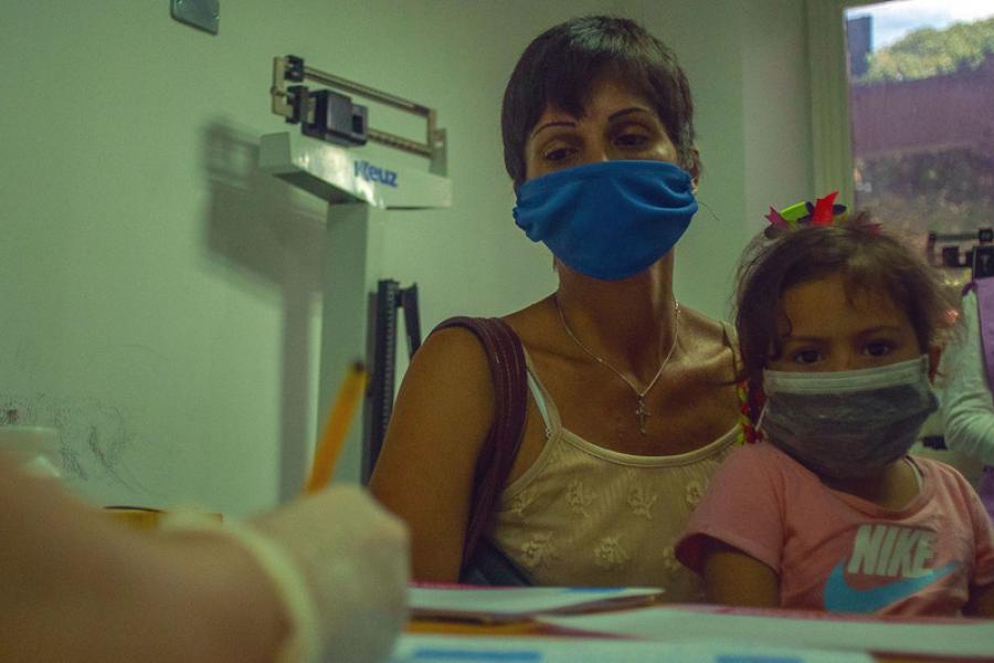 Uma mãe leva sua filha a uma consulta médica em um centro de saúde em Caracas, Venezuela.