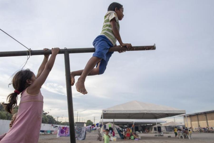 Em Boa Vista, crianças venezuelanas brincam em um varal no Abrigo Pintolândia