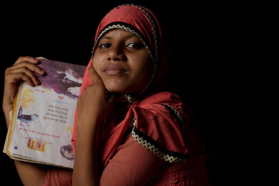 Uma refugiada Rohingya de quatorze anos mostra seu livro de poesia favorito em um campo de refugiados em Cox's Bazaar, Bangladesh.