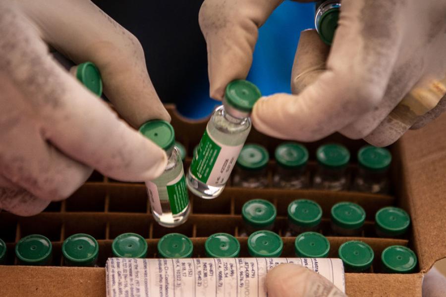 Enfermeiro organiza vacinas em uma caixa