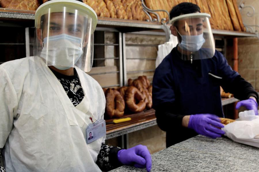 Vendedores em uma padaria em Constantina, na Argélia, durante a crise da COVID-19.