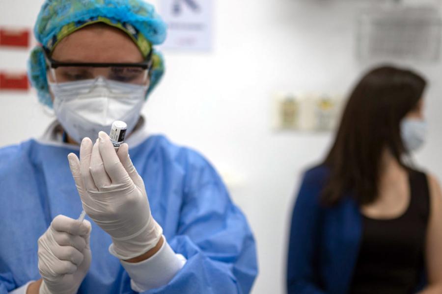 enfermeira prepara seringa para vacina covid