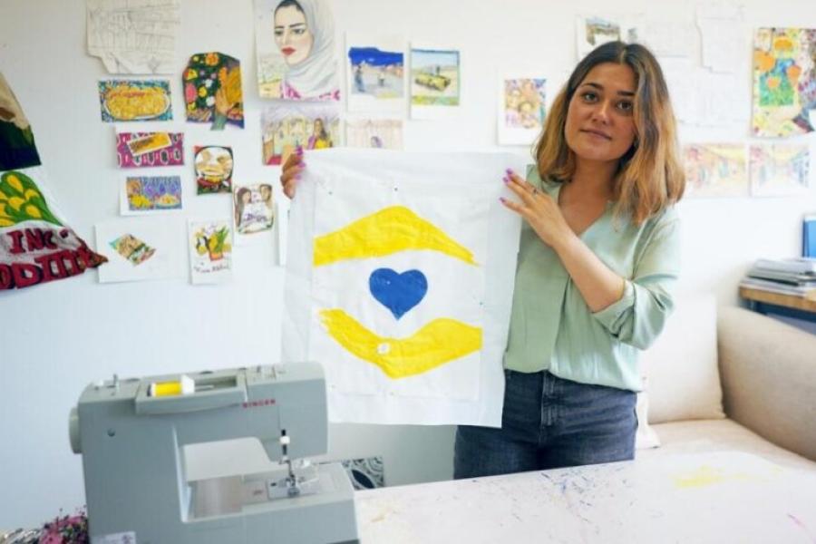 Hangama Amiri segura um poster com o emoji que criou