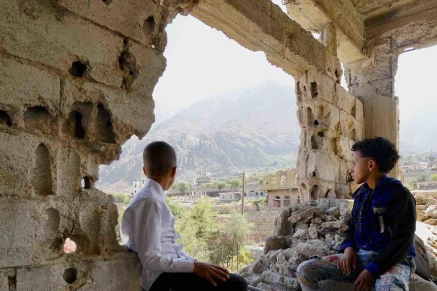 Duas crianças em meio a escombros olham para o bairro de Al Gamalia, na cidade de Taiz.