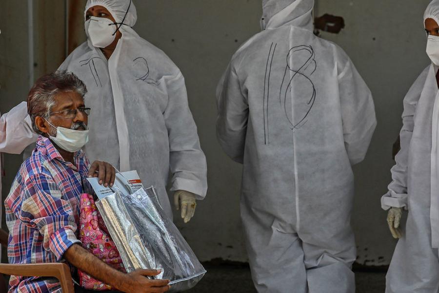 Um homem espera para ser testado para Covid do lado de fora de um hospital em Mumbai, Índia