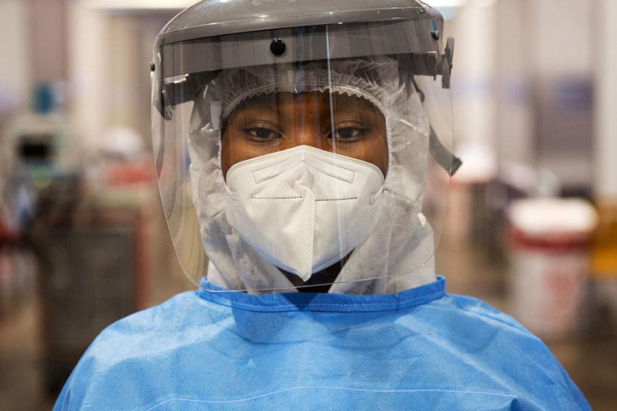 voluntária usa máscara e protetor facial