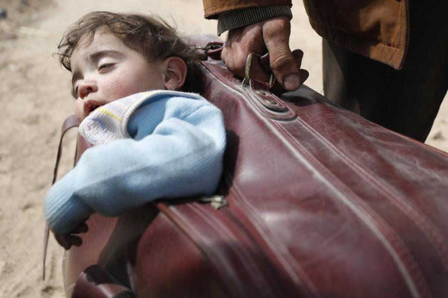 Um homem carregava uma criança em sua mala enquanto fugia do leste de Ghouta em 2018