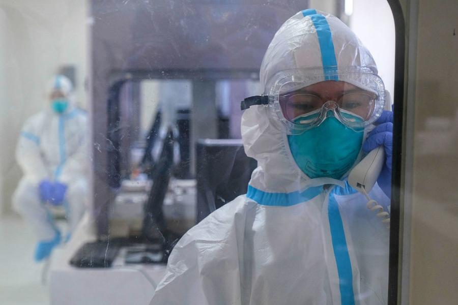 Técnicos médicos testam o equipamento dentro de um laboratório esterilizado durante a inauguração de uma nova instalação nas Filipinas com foco na pesquisa de pandemias