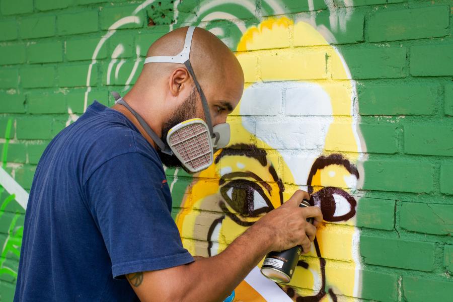 artista pandro nobã pinta um mural de grafite