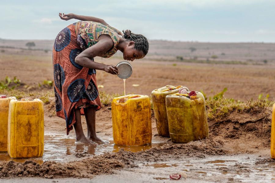 Mulher coleta água da chuva em uma estrada no sul de Madagascar, atingido pela seca