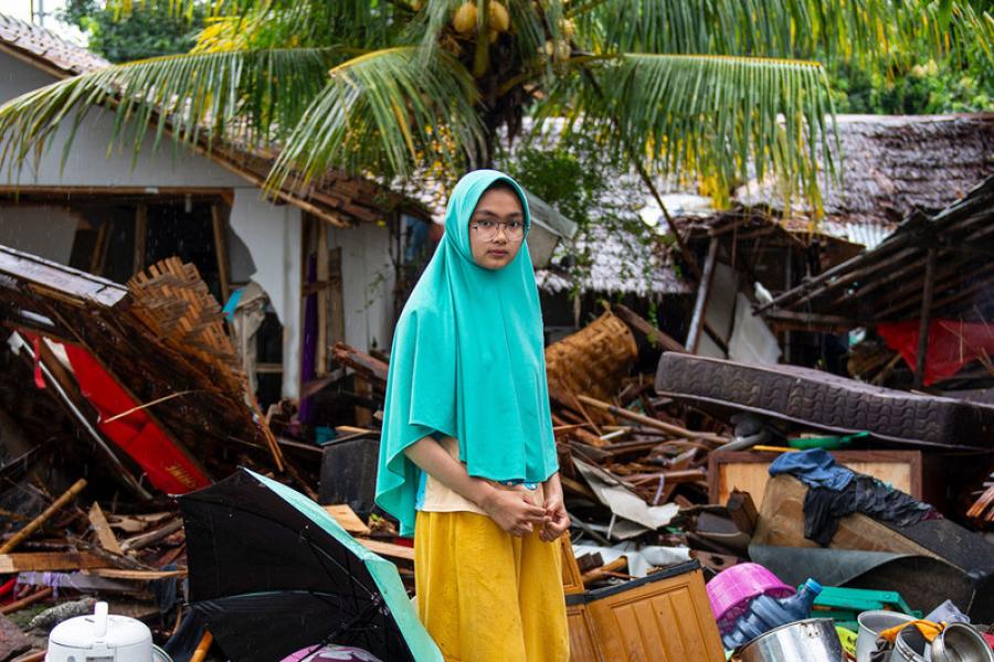 Uma menina do lado de fora de sua casa, que desabou quando um tsunami atingiu Java e Sumatra
