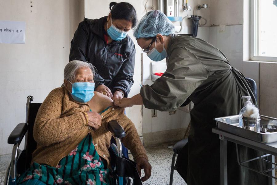 Uma mulher idosa recebe sua vacinação de COVID-19 em um hospital em Kathmandu, no Nepal