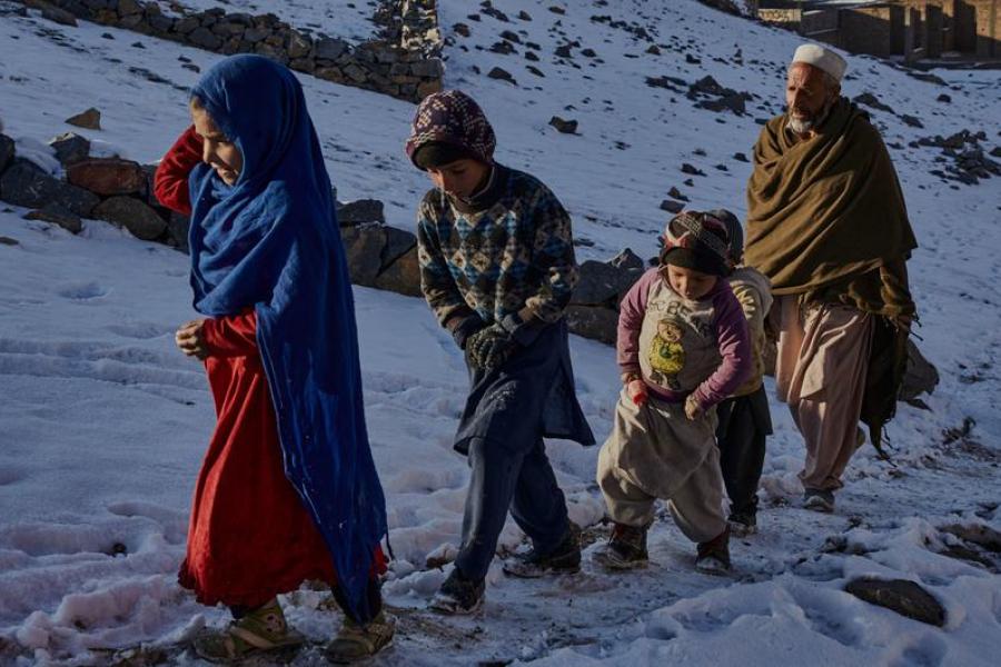 crianças afegãs caminham na neve