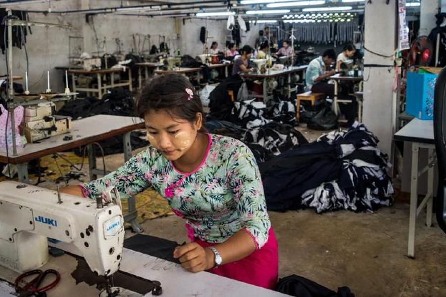 Uma trabalhadora migrante costura roupas em uma fábrica no oeste da Tailândia
