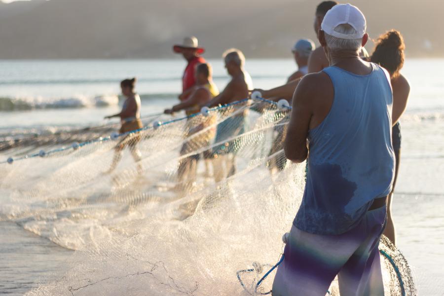 pescadores puxam a rede na praia