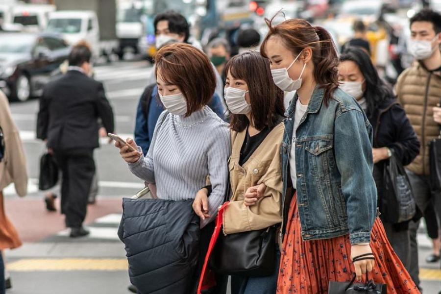 Pessoas com máscaras de proteção andam nas ruas de Tóquio, Japão